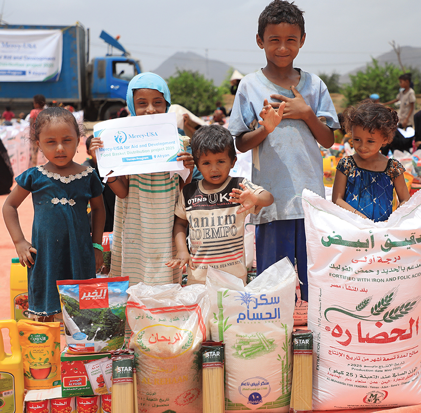 Children with food packages from Mercy-USA